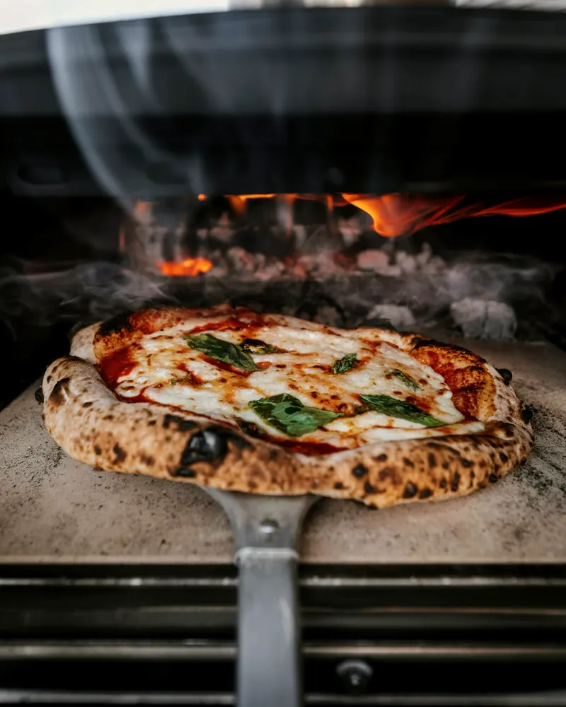 Pizza horneándose frente al fuego